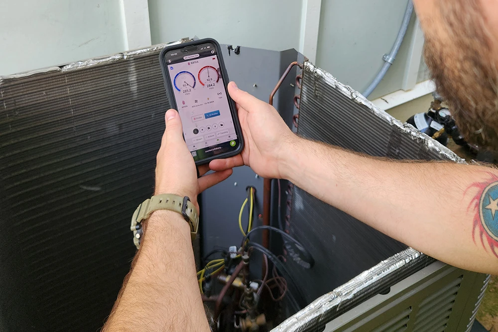 Cumberland Cooling technician diagnoses AC problem with software on tablet