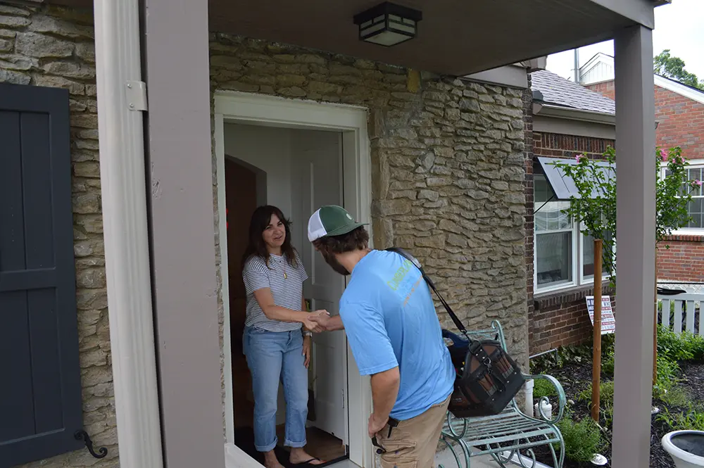 Cumberland Cooling technician shakes hand of customer at her front door