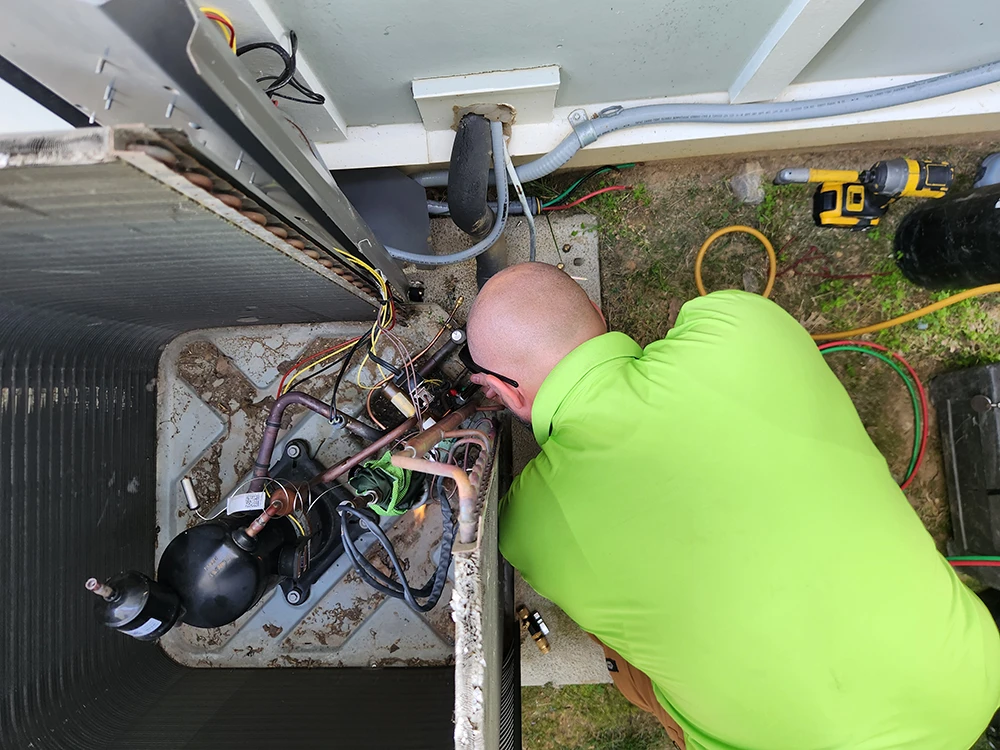 Cumberland Cooling technician repairing an HVAC unit