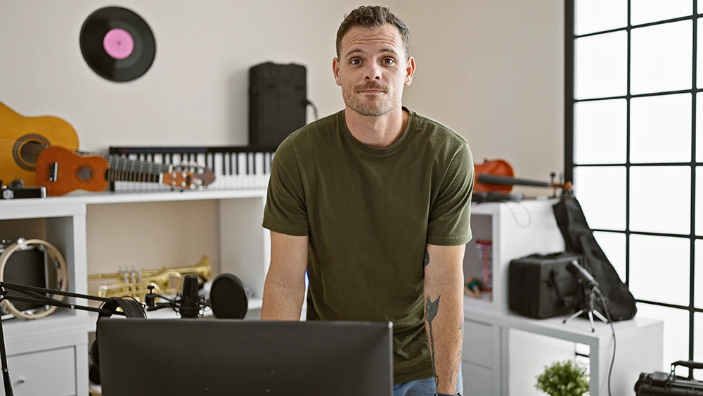 Man standing in his home music studio