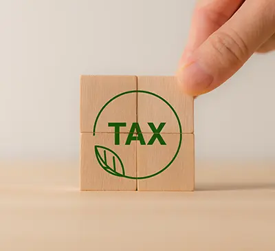 The word tax in a circle with a leaf