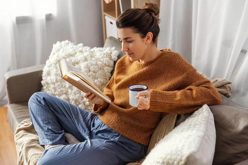 Woman sitting on couch looking cozy